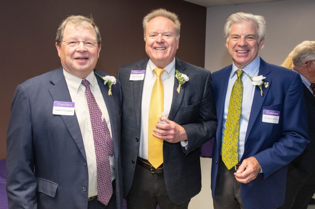 three men wearing ties smiling for photo