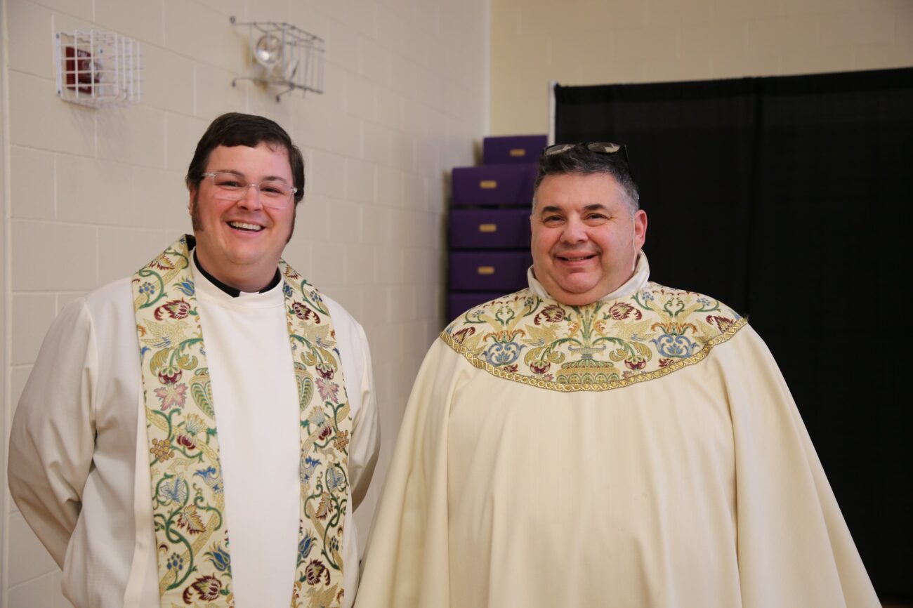 two teachers smiling wearing robes